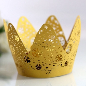 Golden laser-cut crown cake wrapper with intricate snowflake pattern for holiday party decor