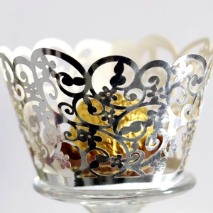 Laser-cut silver metallic cupcake liners with floral scroll patterns for wedding decor