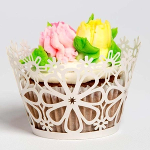 Macro detail of laser-cut floral cupcake wrapper with elegant white hollow pattern