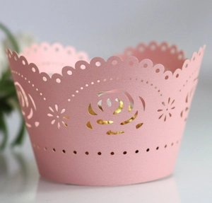 Detail of pink laser-cut cupcake wrapper featuring intricate white rose lace patterns