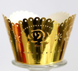 Macro shot of gold laser-cut cupcake wrappers with rose patterns and metallic finish