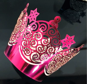 Detailed laser-cut bright pink metallic cupcake wrapper with star and scroll patterns