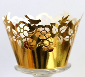 Detailed laser-cut gold cupcake wrapper featuring elegant birds and floral vine patterns