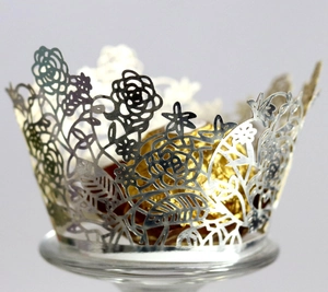 Silver laser-cut floral cupcake wrapper with intricate rose patterns for wedding decor