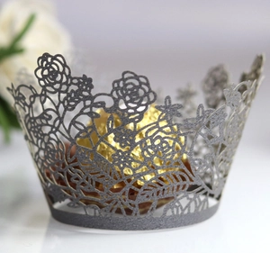 Macro shot of laser-cut rose cupcake wrapper in silver grey with golden chocolate ball