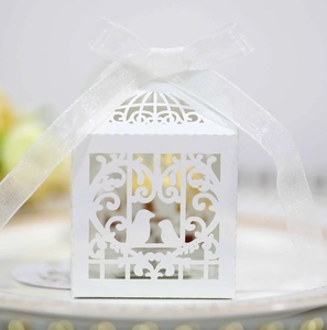 Detail of laser-cut wedding favor box with lovebirds motif and white organza ribbon