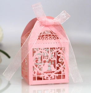 Detail of pink laser-cut wedding favor box with love birds design and ribbon bow