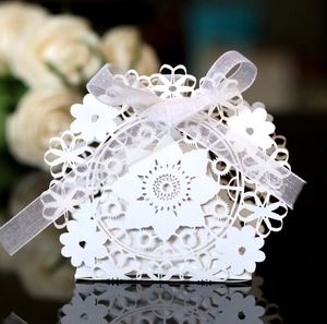 Elegant laser cut white floral gift box with silver ribbon for wedding favors and sweets
