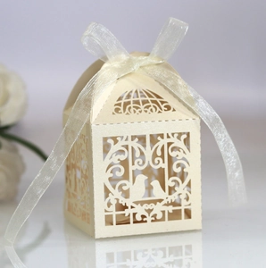 Detailed laser-cut birdcage wedding favor box with cream pearlescent finish and white ribbon