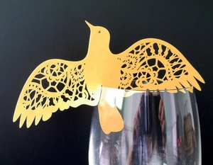 Golden laser-cut bird place card with intricate lace hollow design for wine glass decor