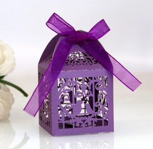 Detail of purple laser-cut love bird candy box with silk ribbon bow for wedding