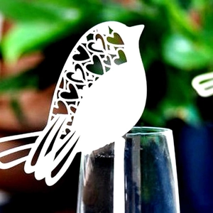 Elegant white laser-cut bird place card with hollow heart pattern for wedding glasses