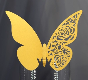 Macro shot of gold butterfly glass card with floral laser cut design for wedding decor