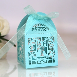 Close-up of laser-cut light blue birdcage candy box with elegant ribbon decoration