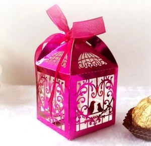 Detail of rose red laser-cut candy box with birdcage pattern and elegant ribbon bow