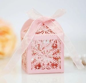 Pink laser-cut snowflake candy box with elegant organza ribbon bow for wedding gifts