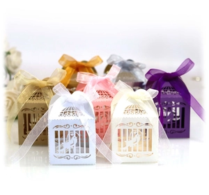 Laser cut bird cage wedding favor boxes in multiple colors with matching silk ribbons