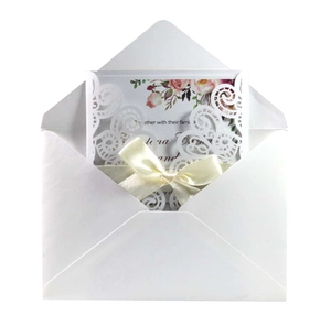 Elegant laser-cut deep red wedding invitation set with floral insert and cream ribbon bow
