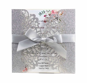 Silver glitter laser-cut wedding invitation with satin bow and floral inner page