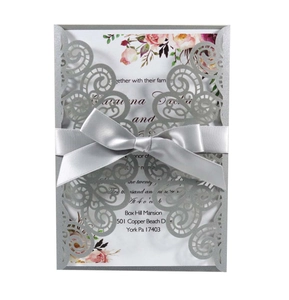 Detailed laser cut hollow wedding invitation with silver glitter finish and ribbon