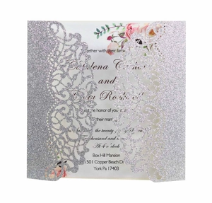 Macro detail of laser-cut glitter silver invitation cover with floral lace patterns