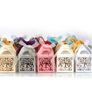 Laser cut bird cage candy boxes in various colors with elegant ribbon bows for wedding favors
