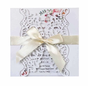 Elegant laser cut wedding invitation with cream ribbon bow and floral inner card