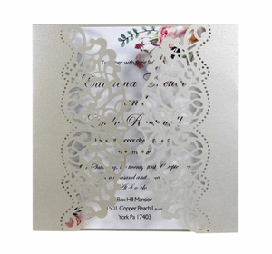 Detailed macro view of laser-cut floral invitation card with champagne pearlescent paper