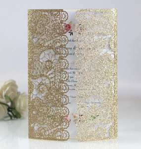 Close-up of laser-cut lace wedding invitation with gold glitter texture and sample text
