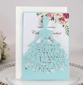 Macro detail of laser-cut princess dress wedding invitation with floral insert card