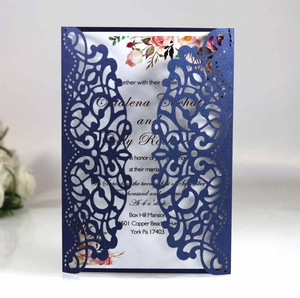 Detail of dark blue laser cut wedding invitation with intricate floral vine patterns