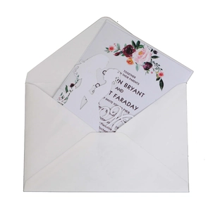 Détail macro de l'invitation de mariage découpée au laser avec motifs floraux et silhouettes