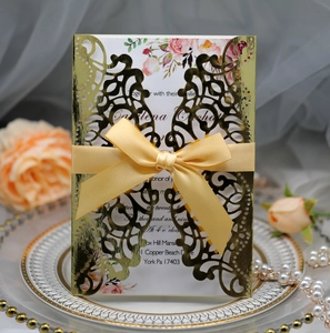 Close-up of laser cut butterfly wedding invitation with elegant gold hollow design and bow