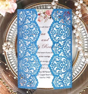 Macro view of navy blue glitter laser cut wedding invitation with floral insert