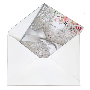 Elegant laser-cut silver glitter wedding invitation with satin bow and floral insert