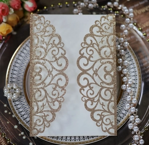 Macro detail of laser-cut wedding invitation with gold glitter and floral patterns