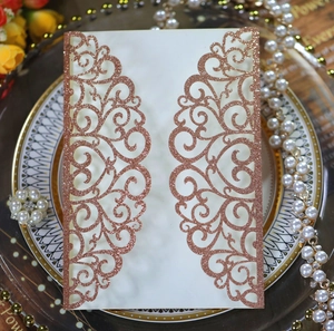 Detail of laser-cut wedding invitation cover with rose gold glitter floral patterns