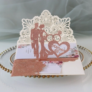 Elegant laser-cut ivory wedding invitation with rose gold glitter Mr & Mrs silhouette