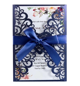 Elegant navy laser-cut wedding invitation with blue satin bow and floral inner card