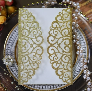 Detailed macro view of laser-cut wedding invitation with golden glitter baroque patterns
