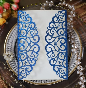 Detail of laser cut blue glitter wedding invitation card with elegant floral lace pattern
