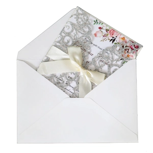 Laser cut silver glitter wedding invitation with floral insert and beige satin bow