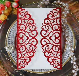 Detail of red glitter laser-cut wedding invitation with elegant hollowed heart patterns