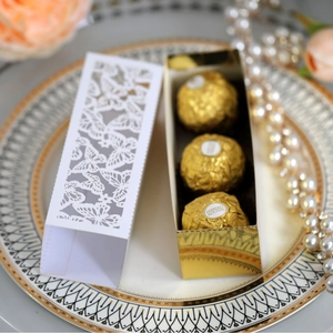 Laser-cut white butterfly favor box with golden inner layer for wedding candies