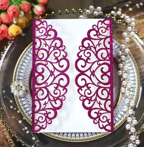 Macro detail of laser-cut purple glitter invitation with intricate baroque heart patterns