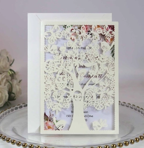 Detail of laser-cut tree and butterfly invitation card with floral insert on glass tray