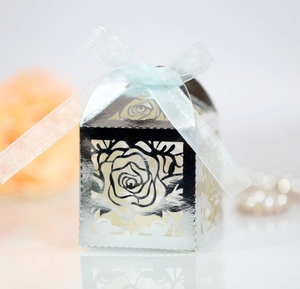 Detail of silver laser-cut rose hollow candy box with light blue chiffon ribbon bow