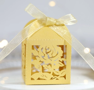 Détail de la boîte à bonbons rose découpée au laser en papier perlé doré avec ruban
