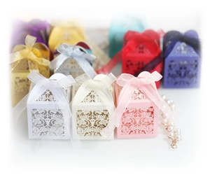 Elegant laser-cut wedding favor boxes with floral patterns and matching ribbon bows