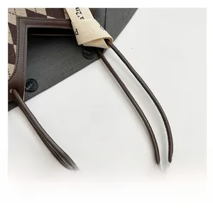 Detail of comfortable brown rounded shoulder straps on a vintage plaid tote bag